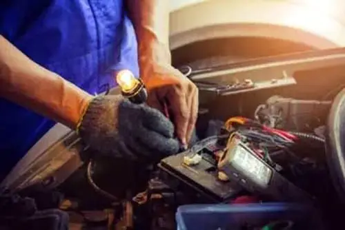 Technician Checking Car Fuse by Lamp Tester